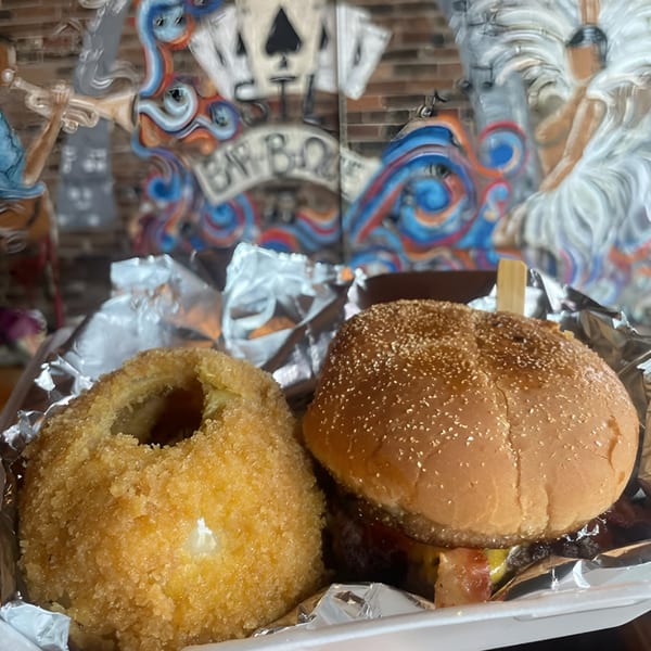 A Five Ace's Smokestaq Lightning BBQ burger with bacon and a large onion ring.